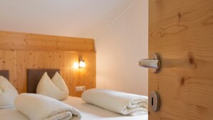 Ein Hotelzimmer mit Holzwandverkleidung, einem Bett mit weißen Leinen und einer Wandleuchte.