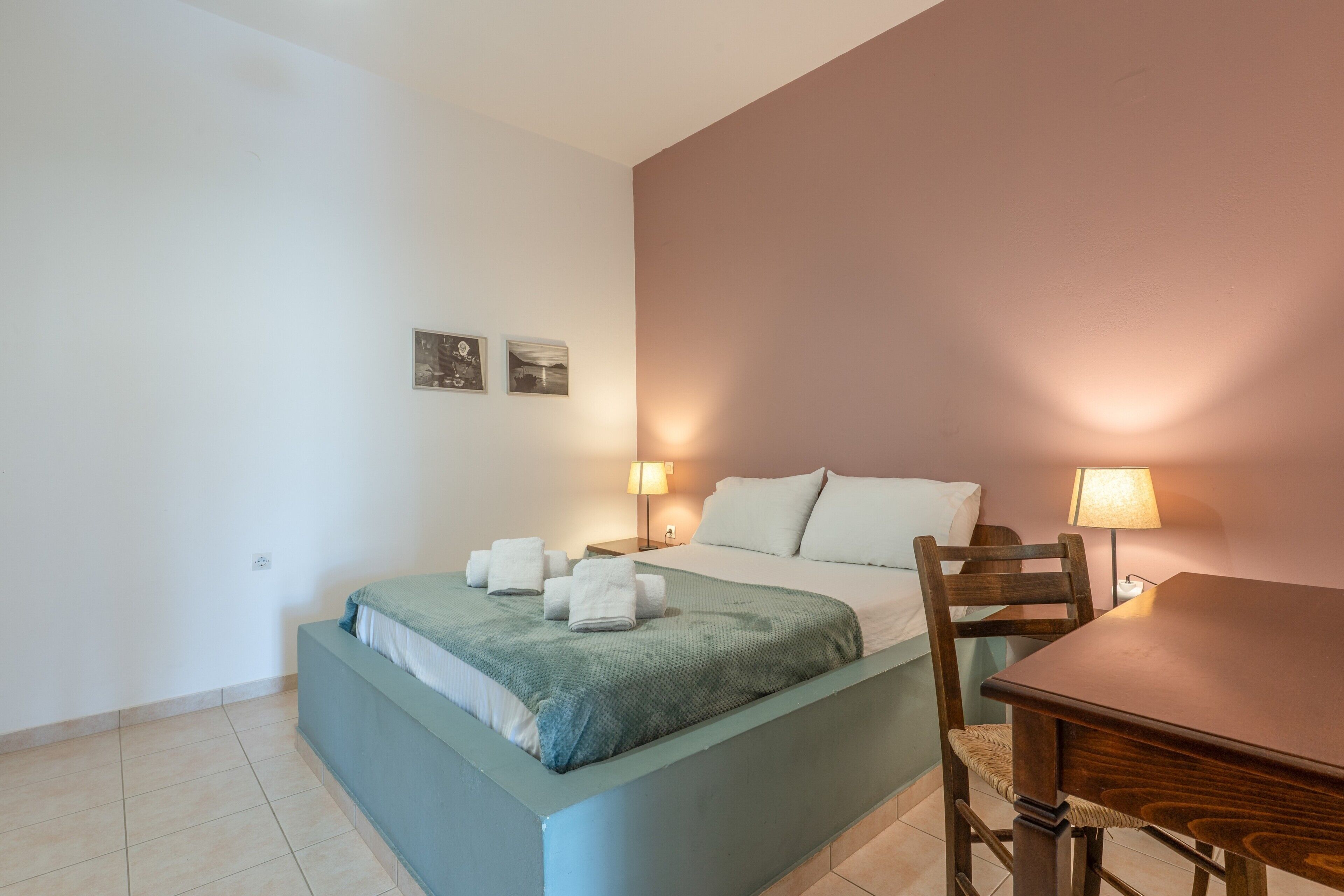 Une chambre à coucher avec un lit, des tables de chevet, une chaise et une table.