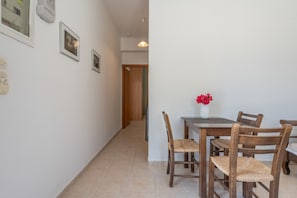 A dining area with a table, chairs, and a vase of flowers. - Holiday Apartment "Standard" with Sea View, 2 Shared Terraces & Wi-Fi (Crete)