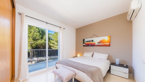 Une chambre à coucher comprenant un lit, un banc, une table de chevet et un tableau représentant un camion.