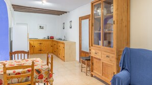 A room with a dining table, chairs, a cabinet, and a sofa. - Holiday Home 'La Clau Casa Rural ' with Mountain View, Private Terrace and Wi-Fi (Polop)