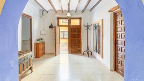 A hallway with a wooden door, a mirror, a dresser, and a hanging coat rack. - Holiday Home 'La Clau Casa Rural ' with Mountain View, Private Terrace and Wi-Fi (Polop)