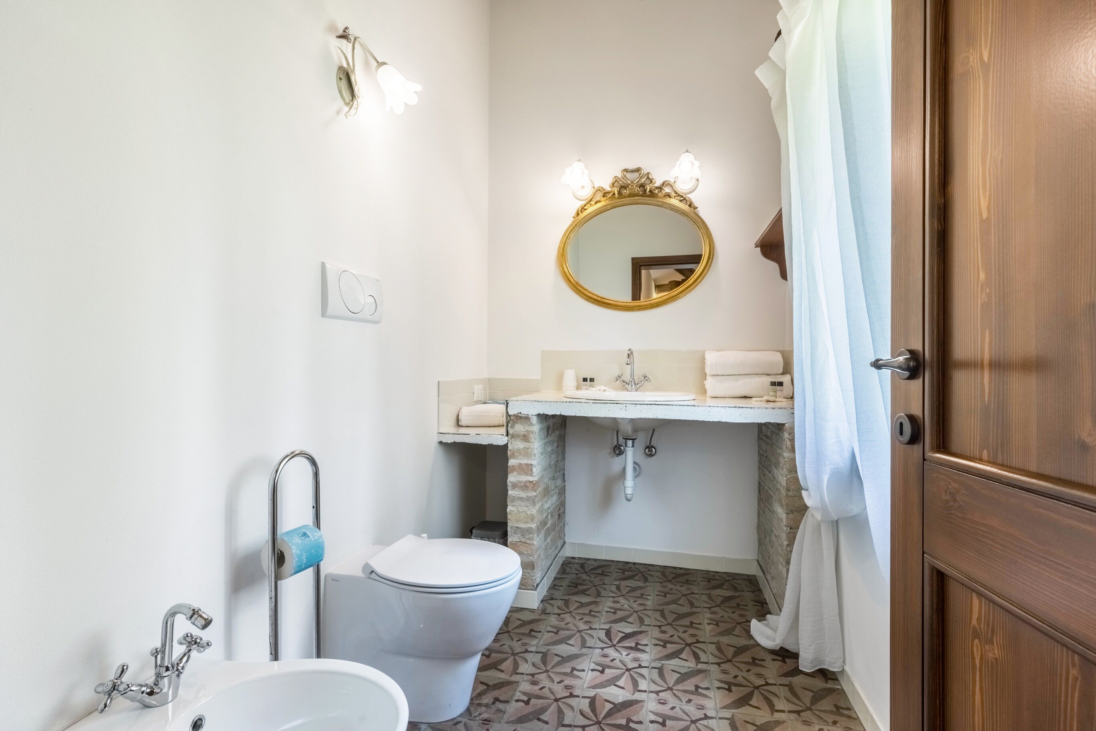 Un baño con inodoro, lavamanos y espejo.