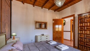 A bedroom with a bed, bedside tables, a dresser, a mirror, and a wooden wardrobe. - Holiday Home 'Villa Verde' with Mountain View, Private Pool and Wi-Fi (Nigüelas)