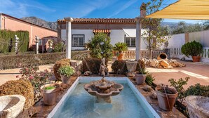A courtyard with a fountain, potted plants, and a pergola. - Holiday Home 'Villa Verde' with Mountain View, Private Pool and Wi-Fi (Nigüelas)