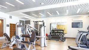 A gym with various exercise equipment, a television, and a mirror on the wall. - Elan Menlo (Menlo Park)