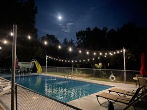A swimming pool with a slide, surrounded by a fence, and string lights overhead. - Resort 2bdrm condo on Table Rock Lake, by SDC! (Branson)