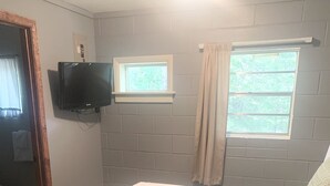 A bedroom with a bed, a television mounted on the wall, and a window with curtains. - Resort 2bdrm condo on Table Rock Lake, by SDC! (Branson)