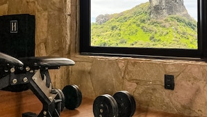 A gym with a view of a mountain through a window. - Hamares Boutique Hotel (Fernando de Noronha)