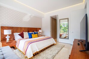Een moderne slaapkamer met een groot bed, nachtkastjes, een televisie en uitzicht op de omgeving.