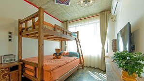 A bunk bed with a wooden frame, a bedside table with a radio, and a potted plant on a wooden table. - China Old Story Inns Dali Elite Garden (Dali)