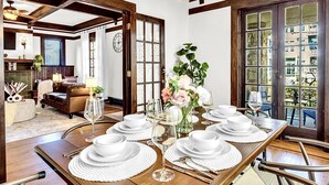A dining area with a wooden table set for six, surrounded by wicker chairs. - 1929 Historic Craftsman Bungalow | King Bed (Atlanta)