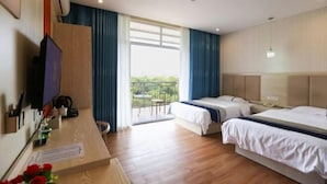 Une chambre d’hôtel avec deux lits, un bureau avec un ordinateur, une télévision et un balcon avec vue.