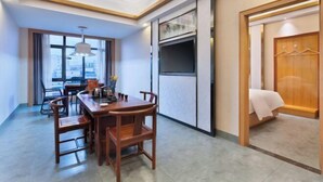 Habitación de hotel con comedor, televisor y armario.