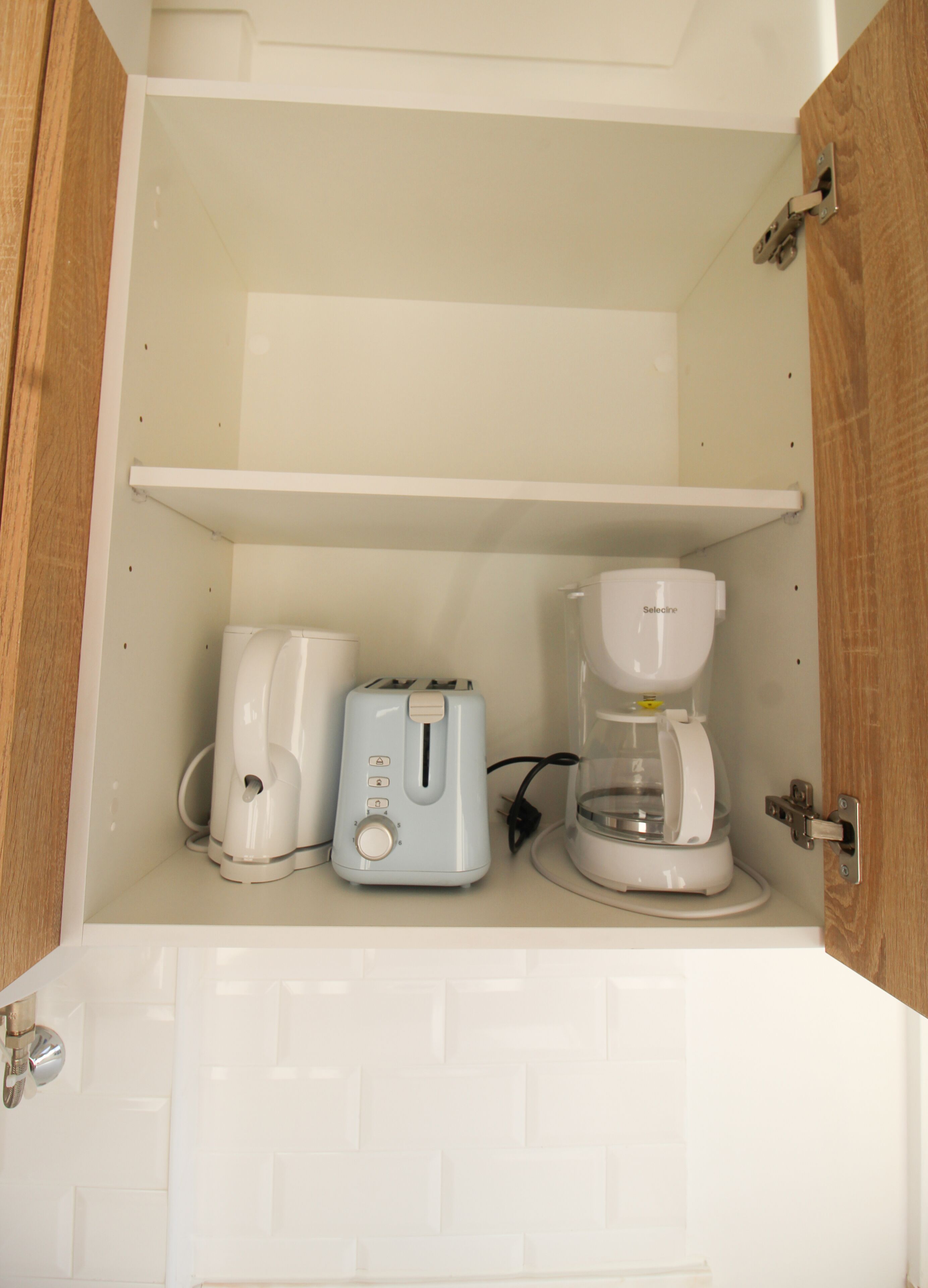 Una kitchenette con un tostador, una cafetera y un lavabo.
