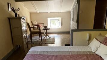 Un dormitorio con cama, escritorio, silla y ventana.