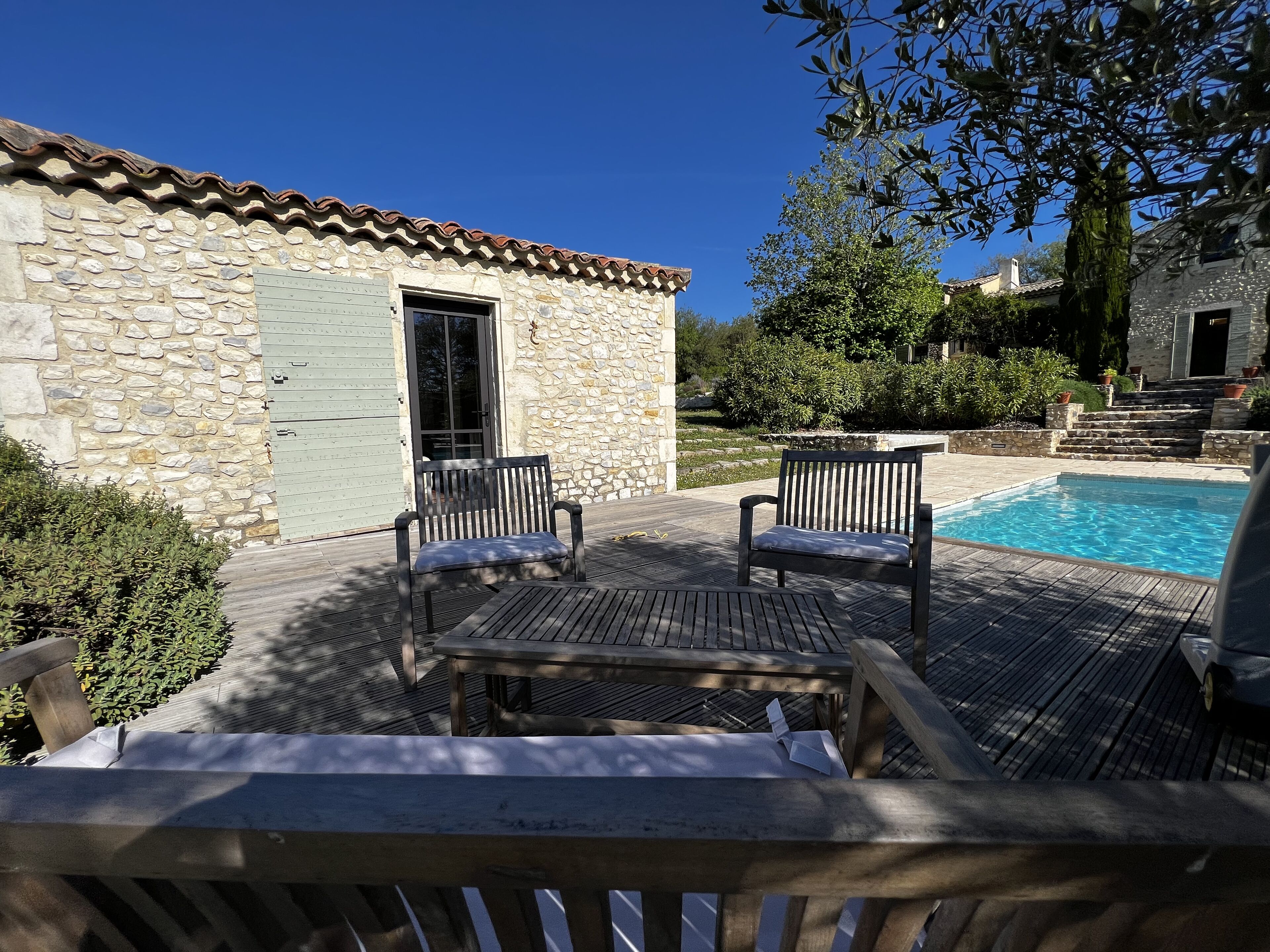 Un bâtiment en pierre doté d’une piscine, d’un espace extérieur aménagé et d’un escalier menant à un niveau supérieur.