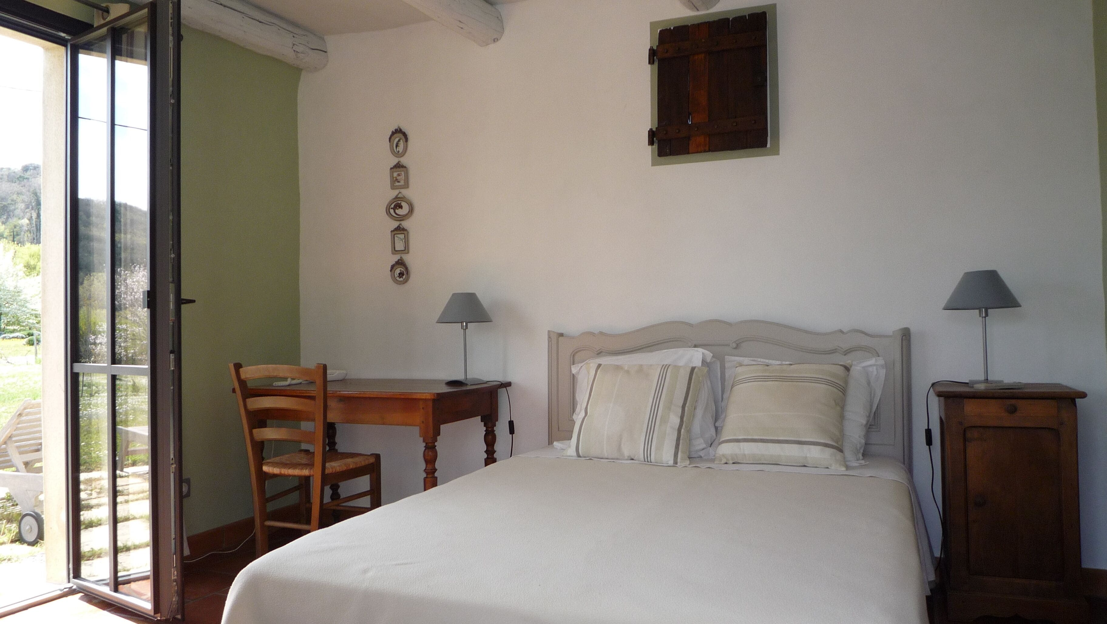 Une chambre à coucher avec un lit, deux tables de chevet, une chaise et une fenêtre.