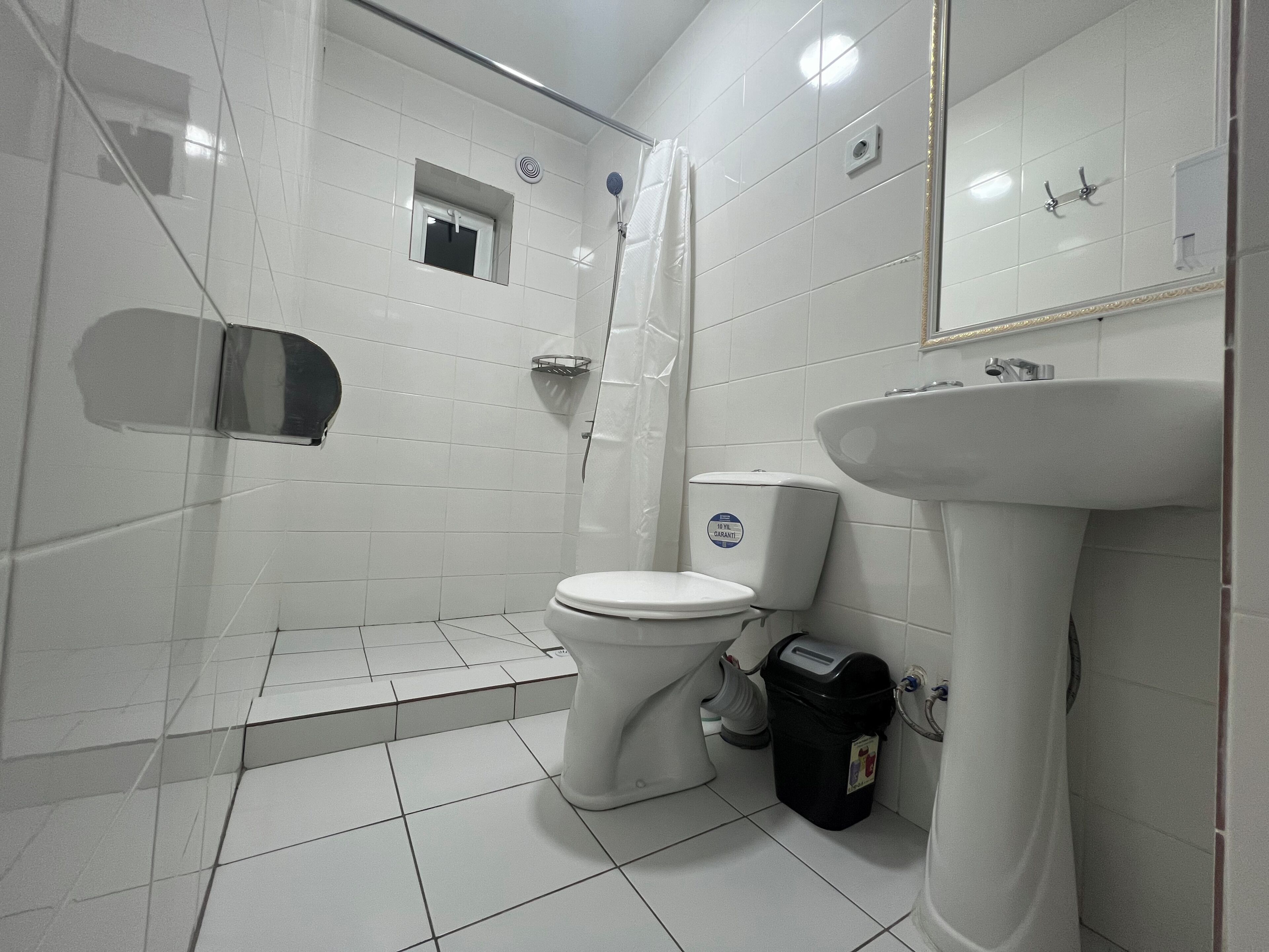 A bathroom with a toilet, sink, and shower.