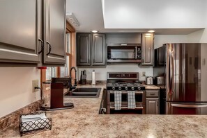 A modern kitchen with stainless steel appliances, a granite countertop, and a built-in oven.