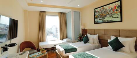 A hotel room with two beds, a desk, a chair, a TV, and a cityscape view.