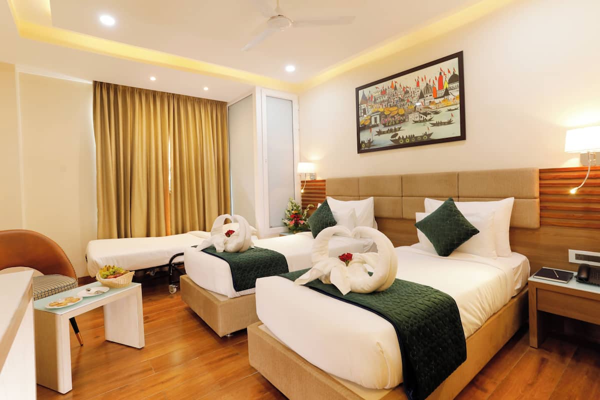 A hotel room with two beds, a desk, a chair, and a painting on the wall.