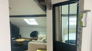 Ett modernt hotellrum med en säng, ett skrivbord, en stol och ett litet runt bord.