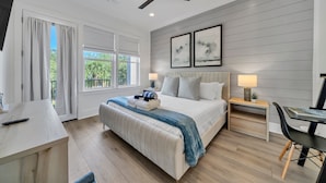 Un dormitorio moderno con cama, mesitas de noche, un escritorio y una silla.