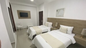 A hotel room with two beds, a TV, a small table, and a chair. - HOTEL CASA AGUSTINA (Cartagena)