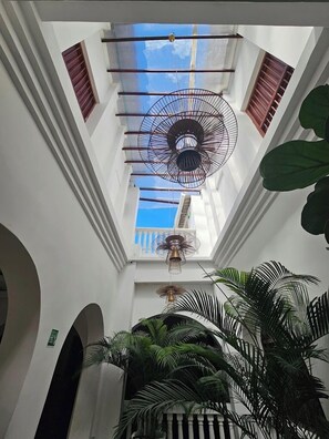 A high ceiling with a central fan, skylights, and a view of the sky. - HOTEL CASA AGUSTINA (Cartagena)