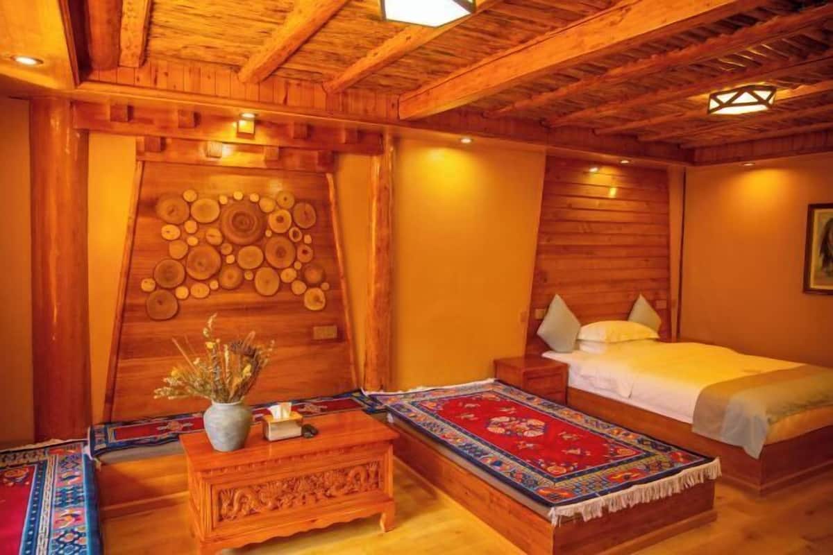 A wooden room with a bed, nightstand, and decorative wall panel.