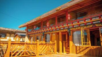 A traditional building with a wooden facade, a balcony with railings, and a staircase leading to the entrance.