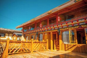 A traditional building with a wooden facade, a balcony with railings, and a staircase leading to the entrance. - Spring Breeze Inn (Shangri-La)