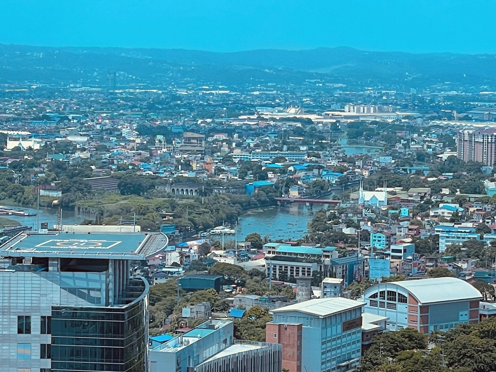 A cityscape with a mix of modern and traditional buildings, a river, and a bridge.