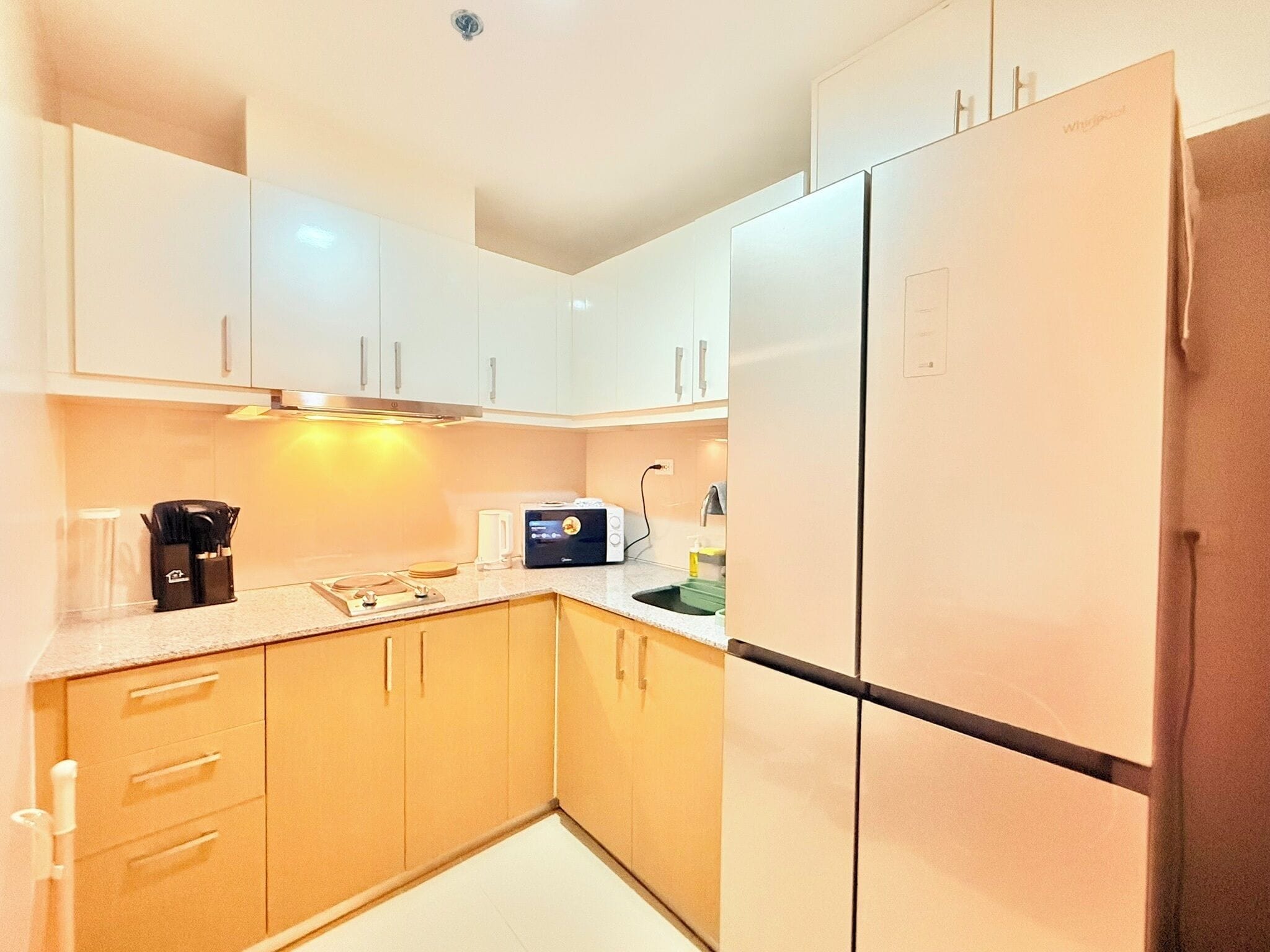 A kitchen with white cabinets, a built-in oven, a coffee maker, and a toaster.