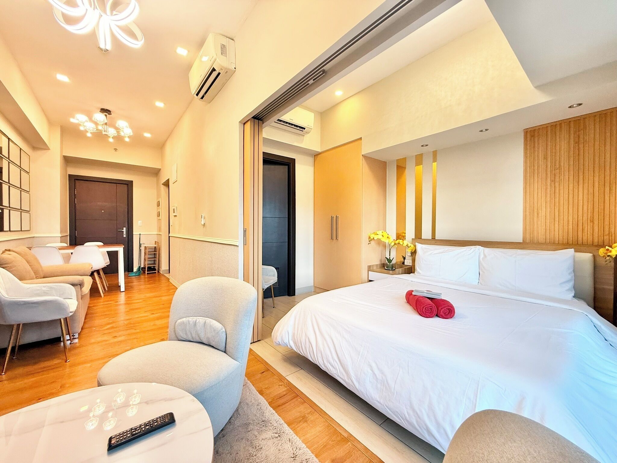 A modern hotel room with a bed, a sofa, a small table, and a chair.