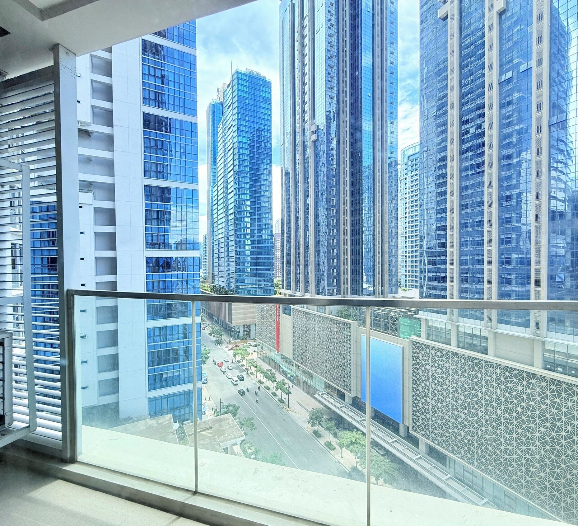 A high-rise building with a glass facade and a view of a cityscape.