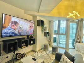 Ein modernes Wohnzimmer mit Flachbildfernseher, Fahrrad, Couchtisch und Sofa.