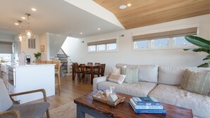 A spacious living area with a wooden ceiling, a dining area, and a kitchen. - Oceanside home - 2 min walk to the beach! Ocean & bay views! (Ship Bottom)
