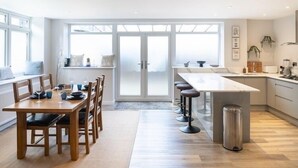 Una cucina moderna con zona pranzo, ampie finestre e isola centrale.
