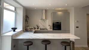 Una cucina moderna con un piano di lavoro in marmo, forno integrato e un'ampia finestra.