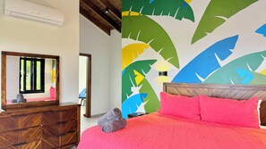 A bedroom with a wooden headboard, a red bedspread, and a colorful wall mural.