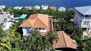 Una zona residenziale costiera con case immerse nel verde e vista sul mare.