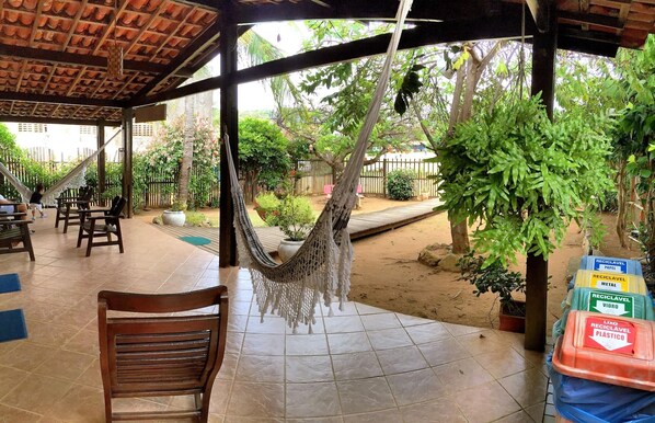 An outdoor seating area with wooden chairs and a hammock.