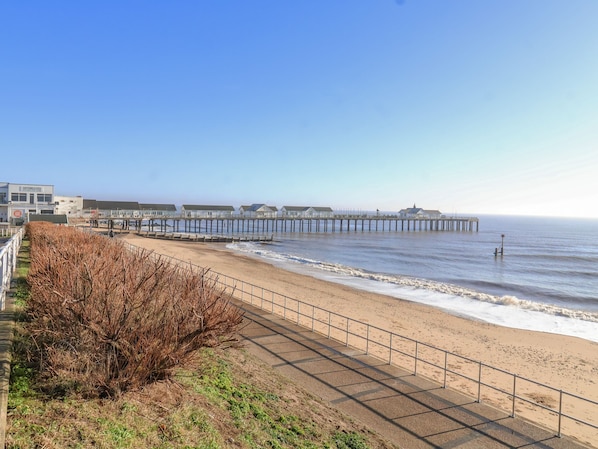 A beach with a long pier extending into the sea, a sandy walkway, and a building labeled "Southend Pier."