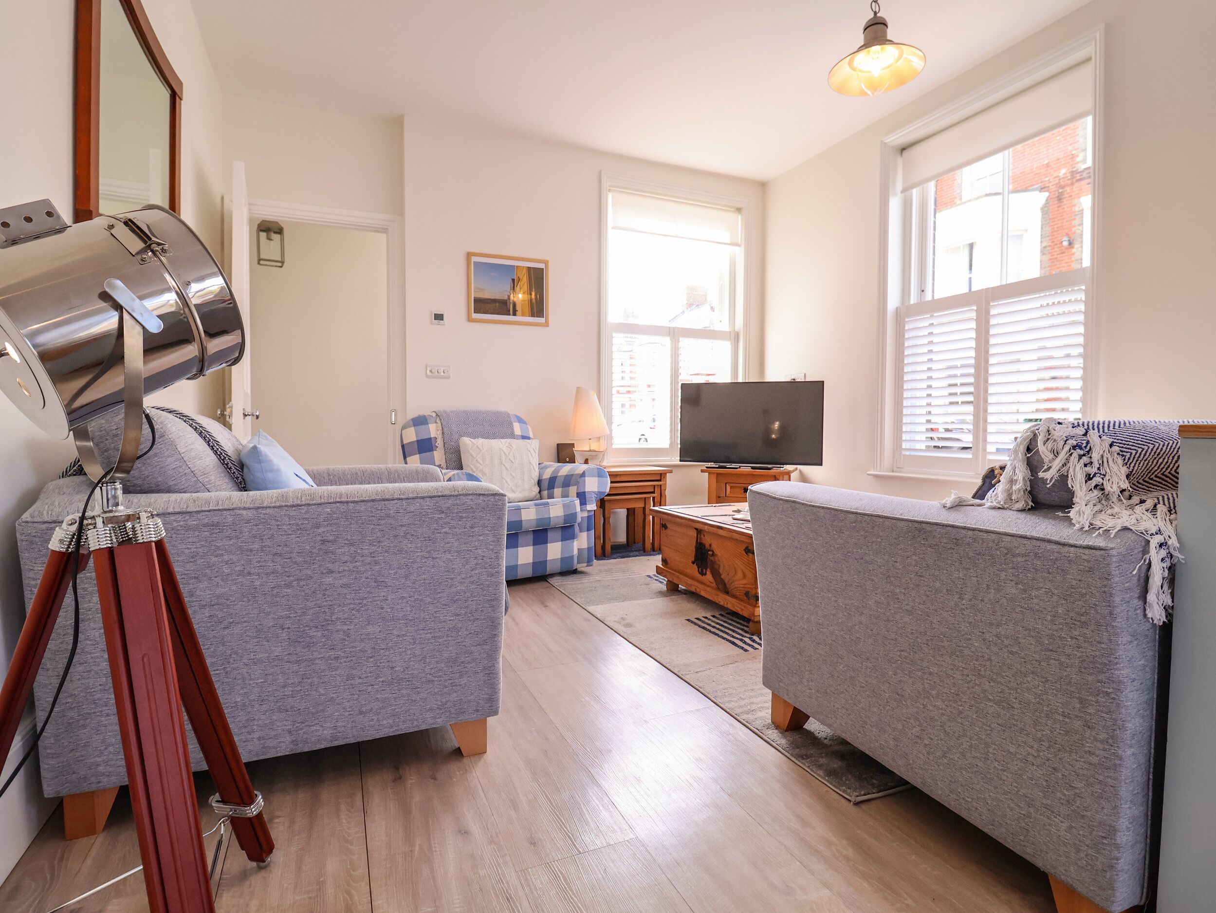 A living room with two grey sofas, a wooden coffee table, a TV, and a lamp.