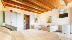 A bedroom with a bed, a chair, a desk, a wardrobe, and a television. - Tenuta Cavalieri - Camera Quadrupla (Leverano)