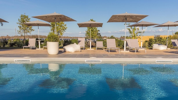 A swimming pool with lounge chairs and umbrellas, surrounded by greenery. - Tenuta Cavalieri - Camera Quadrupla (Leverano)