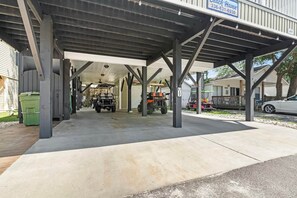 A covered parking area with a sign for Beach Haven, a covered walkway, and a utility vehicle.