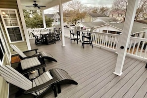 A covered porch with outdoor furniture and a white railing. - Upscale Beach House-Linens|Golf Cart|Quiet Area (Myrtle Beach)